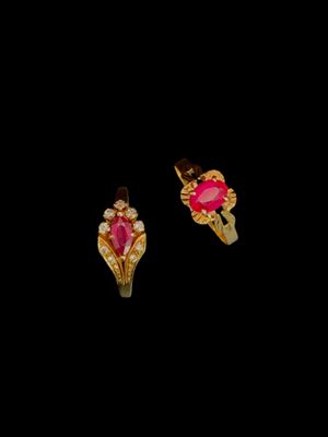 une paire de boucles d'oreilles roses et dorées sur fond noir
