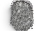 a close up of a metal mesh purse on a white surface