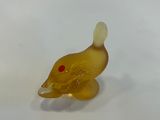 a small yellow duck figurine sitting on a white surface