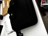 un sac noir posé sur un bureau, à côté d'un ordinateur portable