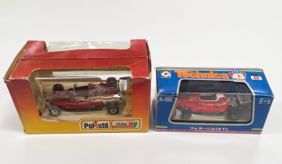 une petite voiture rouge dans une boîte et une petite voiture rouge dans une boîte