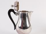 an image of a silver pitcher with a black handle on a white background