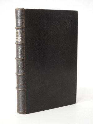 un vieux livre noir posé sur une table, devant un fond blanc
