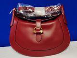 un sac à main rouge sur lequel est posé un sac en plastique