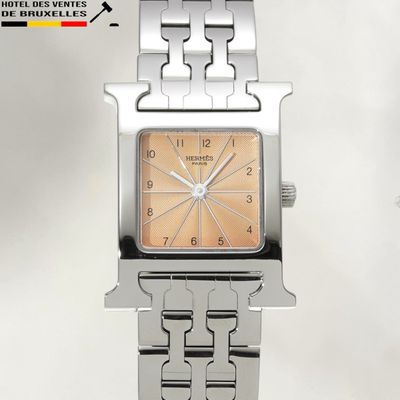 une montre en argent avec un cadran marron et un bracelet en argent