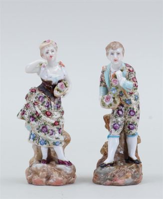 pair of porcelain figurines of a man and a woman on a rock