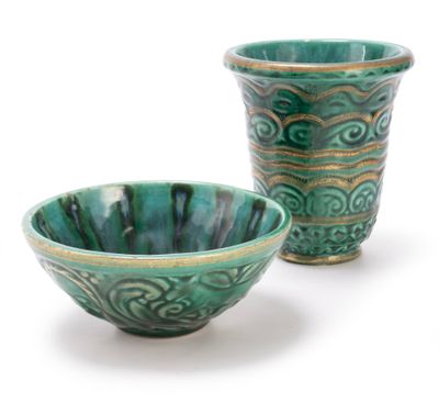 two green bowls sitting next to each other on a white surface