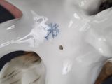 a white porcelain figurine with a blue design on it
