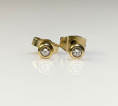 a close up of a pair of gold and diamond earrings