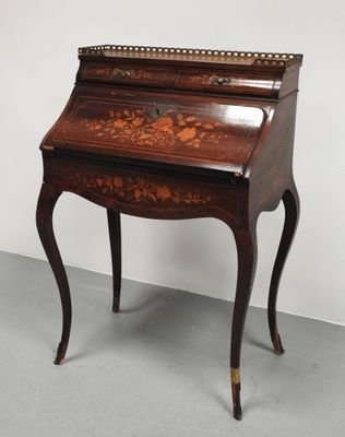 un bureau ancien orné d'un motif floral sur le plateau