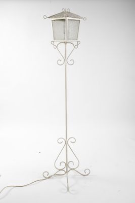 un lampadaire en métal blanc surmonté d'un abat-jour blanc