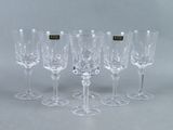 six verres à vin sont alignés sur une table