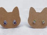 a pair of cat shaped earrings with multi colored crystals on them