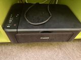 a canon printer sitting on top of a yellow cabinet