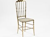 a gold metal chair with a cushion on the back of it