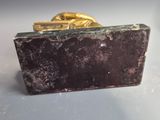 a black and gold purse sitting on a white surface