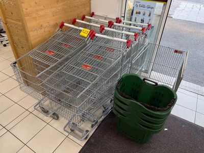 many shopping carts lined up in a row in a store