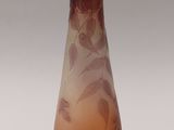a glass vase with leaves on it sitting on a table