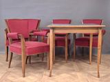 four chairs and a table in a room with a grey wall