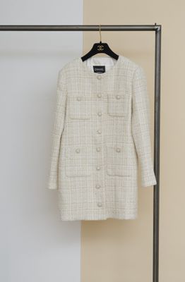 un manteau suspendu à un portant dans une pièce aux murs blancs