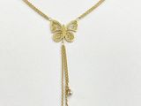 un collier représentant un papillon doré orné de perles sur fond blanc
