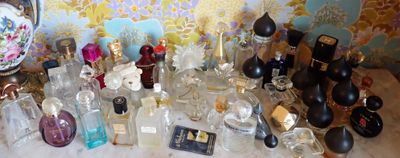 de nombreux flacons de parfum posés sur une table devant un mur