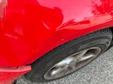 a close up of a red car with a broken tire