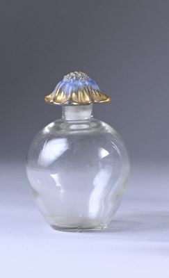 a small glass jar with a gold lid on a white surface
