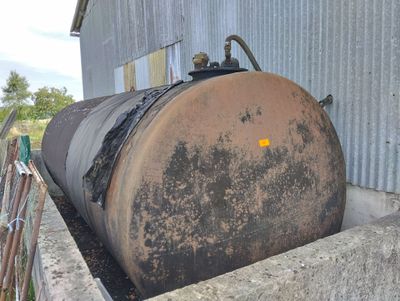 a large metal tank sitting in the middle of a cement wall
