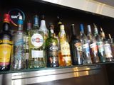 Des bouteilles d'alcool sont alignées sur une étagère dans un bar