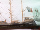 a ship in a glass bottle on a table