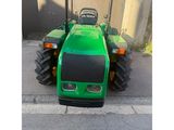 a green tractor that is parked on the side of the road