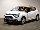 La petite voiture blanche est garée dans le garage.