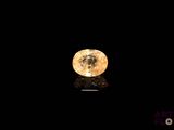 a close up of a yellow diamond on a black surface