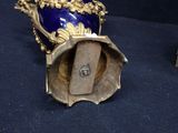 a blue vase with a gold decoration on top of it