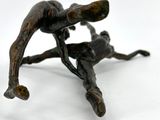 bronze figurine of a man and a dog on a white surface