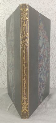 an old book sitting on top of a white table next to a white wall