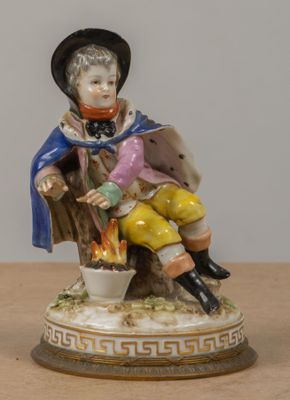 une figurine représentant un garçon assis sur une souche d'arbre