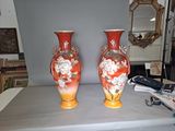 two vases sitting on a table with a mirror in the background
