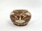 a brown vase with a white design on it