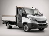 La petite camionnette blanche est garée sur une surface grise.