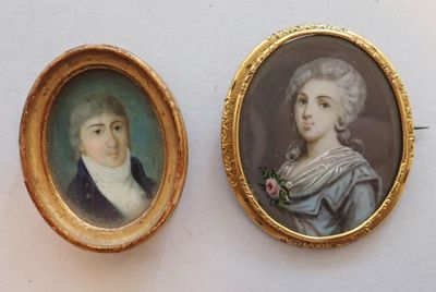 two miniature portraits of a man and a woman in a gold frame