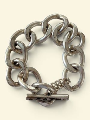 a silver chain bracelet with a clasp on a white background