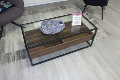 une table basse en verre sur laquelle est posé un bol