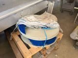 a pile of blue brushes on a pallet in a warehouse