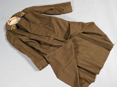 une photo montrant un manteau et un pantalon marron posés sur une surface blanche