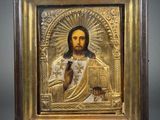 a gold - plated icon of jesus holding a book
