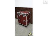 une image montrant une valise rouge posée sur un sol en béton