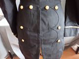 a black jacket with gold buttons on it on a mannequin