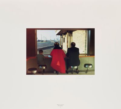 an image of two people sitting on a bench at a train station